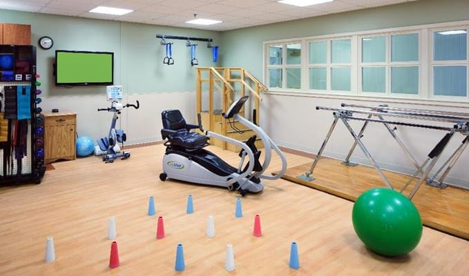 Exercise equipment in a therapy room with a green ball and cones.