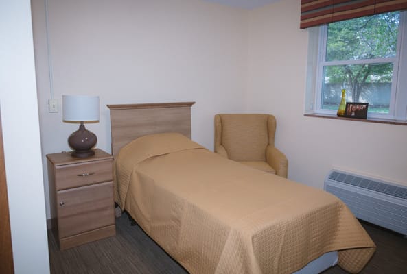 Cozy resident room with a bed and chair