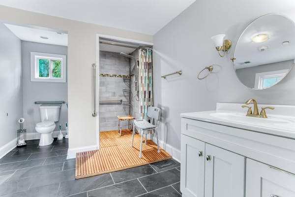 Accessible bathroom featuring a shower seat and grab bars.