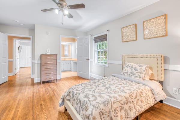 A well-furnished bedroom with a bed and dresser.