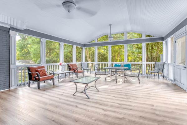 Spacious sunroom with seating and green views