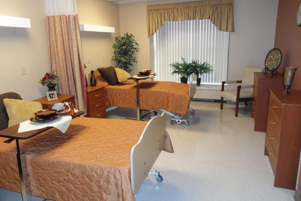 A shared bedroom with two beds and a small table, featuring warm decor