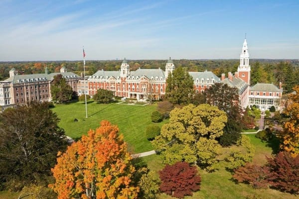 Aerial view of The Osborn Senior Living facility surrounded by colorful autumn trees.