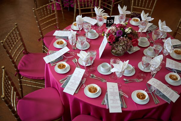 Table set for an event with floral centerpiece and menus