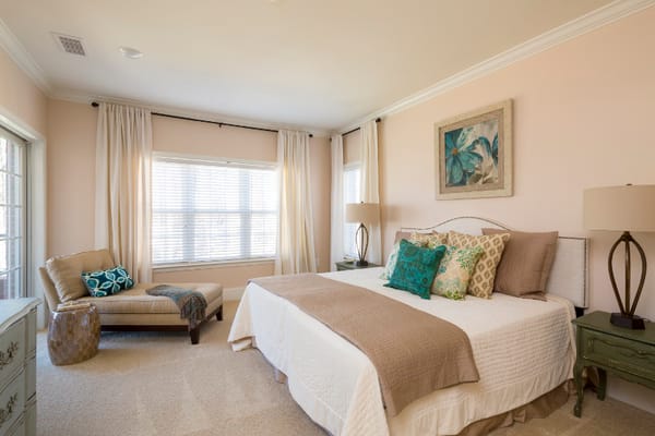 Bright bedroom with a queen bed and lounge chair