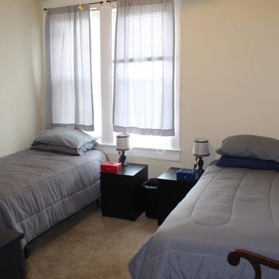 Two twin beds in a shared bedroom with natural light