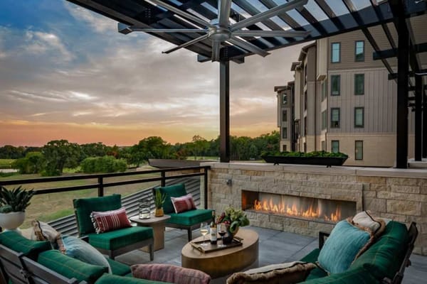 Stylish outdoor seating area with a fireplace at sunset