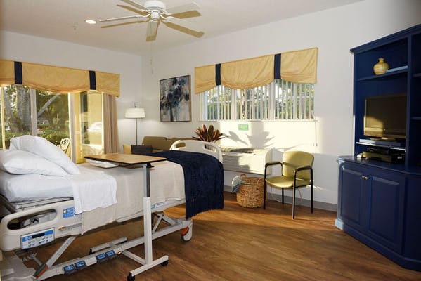 Comfortable patient room with bed, seating, and natural light