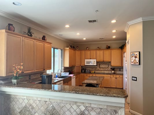 Bright kitchen with wooden cabinets and a granite countertop.