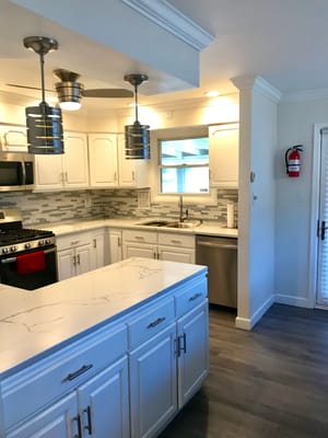 Spacious and modern kitchen with white cabinetry and stainless steel appliances.