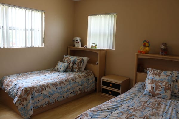 A cozy shared resident room with twin beds and light decor