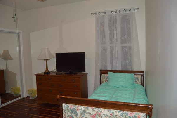 Bedroom with a bed, TV, dresser, and lamp