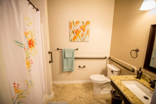 Accessible bathroom with floral shower curtain and modern fixtures