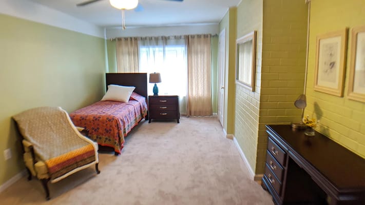 Interior view of a private resident room with bed and furnishings