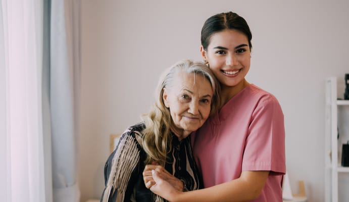 A caregiver and a resident smiling together