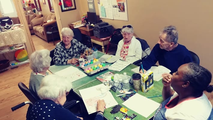Residents engaging in a coloring activity around a table