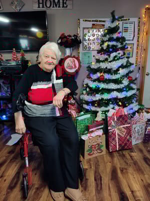 Resident sitting beside a decorated Christmas tree