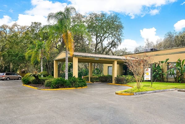 Entrance of Fairway Oaks Center with greenery and parking area