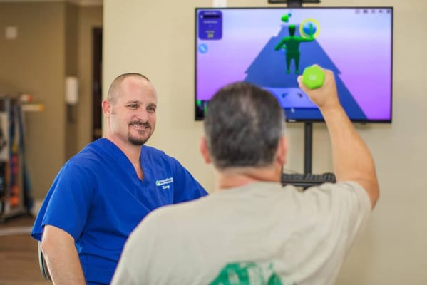 Staff assisting resident with a virtual exercise activity