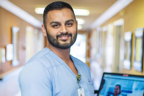 Healthcare staff member smiling in a hallway