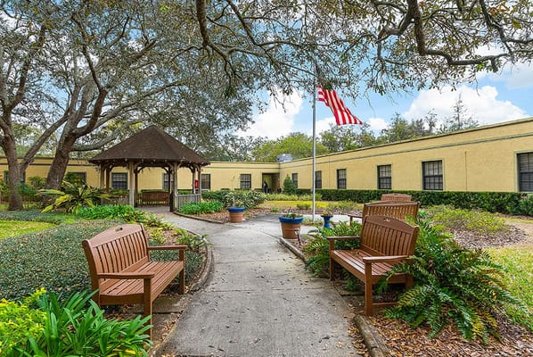 Outdoor pathway with benches and gazebo in a senior living community