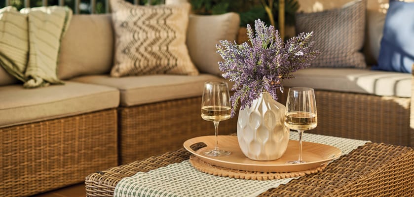 Cozy outdoor seating area with wine glasses and flowers