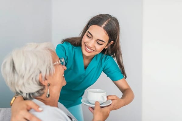 A caregiver serving tea to a resident