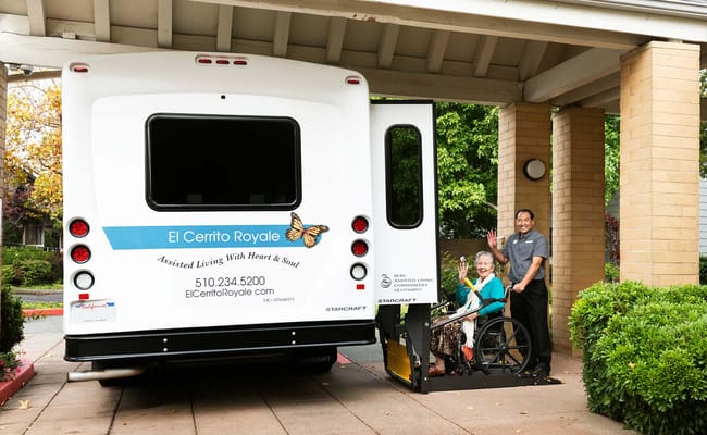 Facility transport vehicle with staff assisting a resident