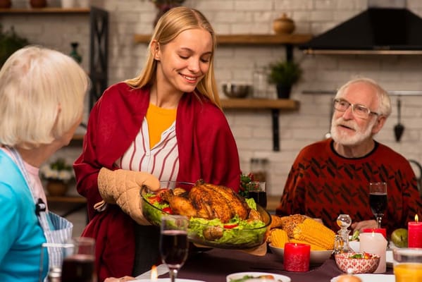 A resident serving a turkey dinner at a dining table
