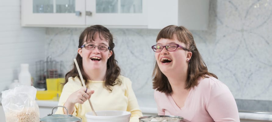 Two residents enjoying a cooking activity in the kitchen