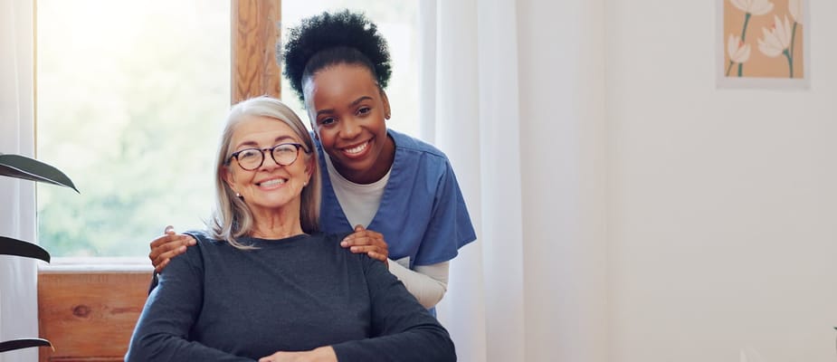 A caregiver smiling with a resident in a cozy interior