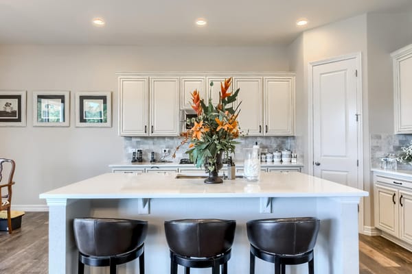 Bright kitchen with floral centerpiece and bar stools