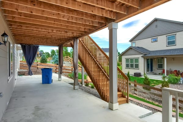 Covered outdoor space with wooden stairs and building view