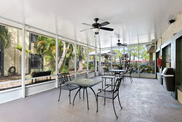 Outdoor seating area with tables and fans