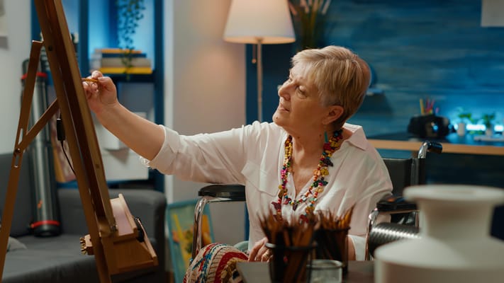 Resident painting in a bright activity room