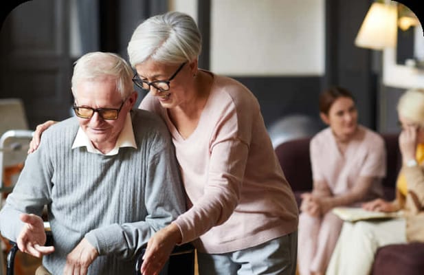 Staff assisting a resident in a cozy common area