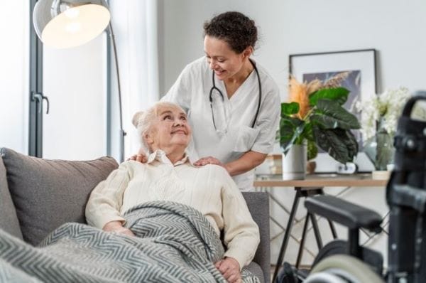 Nurse assisting an elderly resident in a cozy living area