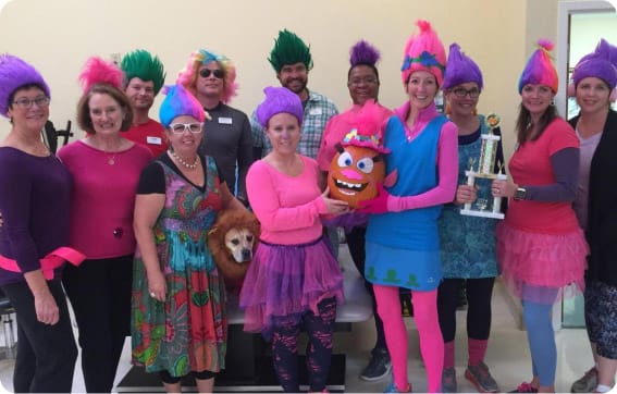 Staff and residents celebrating in colorful costumes