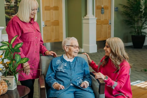 Residents interacting with staff in a cozy lounge