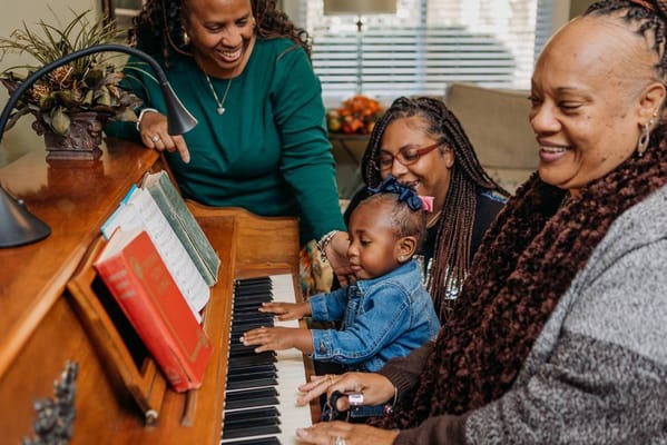 Residents and staff enjoying music at a piano