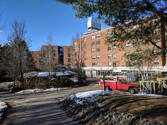 Exterior view of Golda Meir House with trees and a red truck