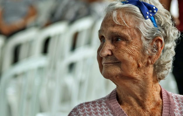 Elderly woman smiling during a community event