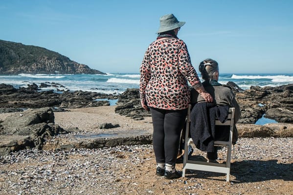 Two people enjoying a beach view by the ocean