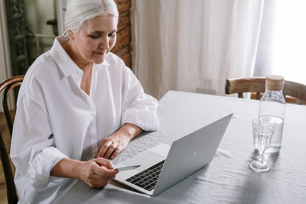 Senior woman using a laptop at a table
