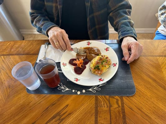 A resident enjoying a meal at a dining table