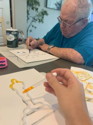 A resident engaged in arts and crafts activity.