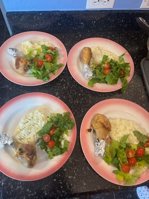 Plates of food including chicken, rice, and salad
