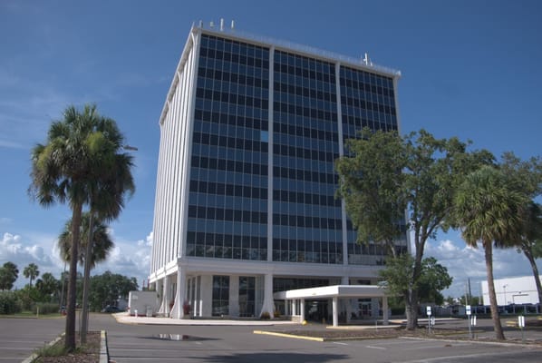 Exterior view of a tall building with palm trees