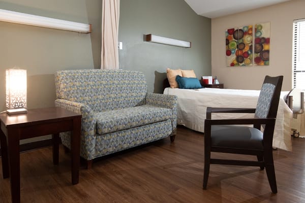 A cozy resident room with a couch and bed