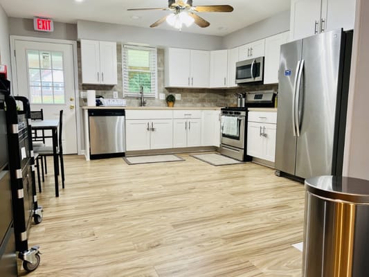 Bright modern kitchen with stainless steel appliances and wooden flooring
